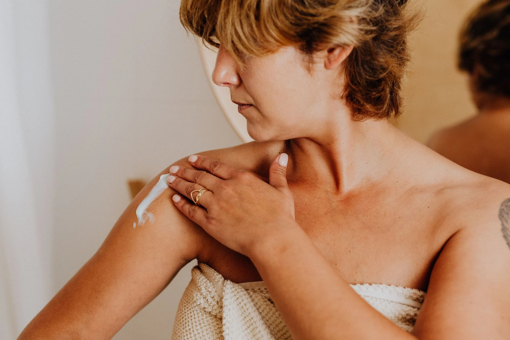 Body moisturiser being applied to a shoulder